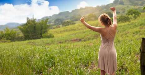 relaxation and vacation concepts. beautiful young caucasian woman contemplates beautiful scenery and stretches her arms in the air and feels inspired. freedom and fresh air