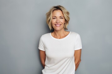 Poster - Portrait of a blissful woman in her 40s dressed in a casual t-shirt isolated in blank studio backdrop