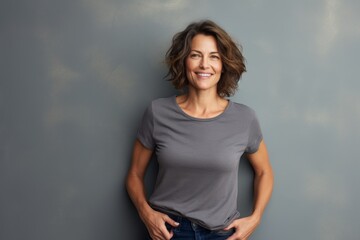 Poster - Portrait of a blissful woman in her 40s dressed in a casual t-shirt isolated on blank studio backdrop