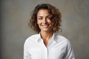 Sticker - Portrait of a smiling woman in her 30s wearing a simple cotton shirt in empty modern loft background