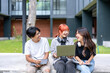© Wasana - Three young people are sitting on a cement ledge, laughing and smiling