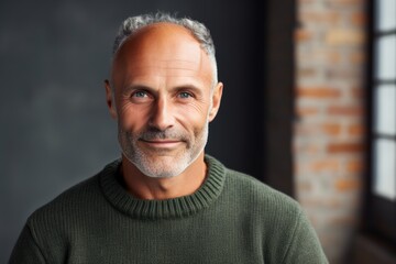 Poster - Portrait of a satisfied man in his 50s dressed in a warm wool sweater isolated on empty modern loft background