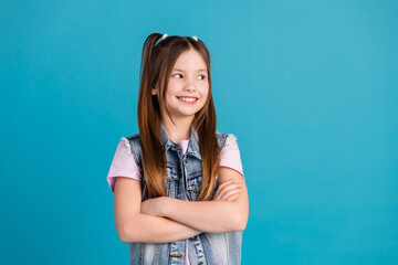 Sticker - Photo portrait of cute little girl crossed hands look empty space dressed stylish denim clothes isolated on blue color background