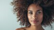 © AlfaSmart - Beautiful woman with a voluminous curly hairstyle, captured with natural lighting and a neutral background