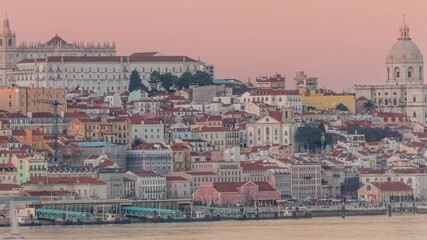 Wall Mural - Panorama of Lisbon historical center and ferry terminal Terreiro do Paco aerial timelapse during sunset from above. Mosteiro de Sao Vicente de Fora and Pantheon. Buildings with red roofs. Portugal