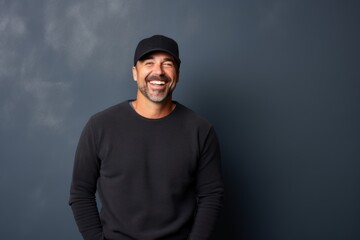 Wall Mural - Portrait of a happy man in his 40s sporting a trendy beanie while standing against plain cyclorama studio wall