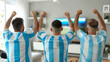 © Luluraschi - rear view of cheerful and excited argentinian futbol soccer fans supporting Argentina's national futbol soccer team at home. fans watching soccer match on TV