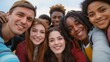 © Roberto - Young people from different cultures giving each other hugs and grinning at the camera - A contented group of pals taking an outside selfie.