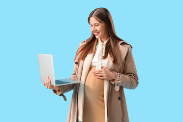 Sticker - Young pregnant businesswoman with laptop on blue background