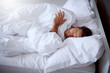 © JorSons/peopleimages.com - Sleeping, fatigue and man in bed in home for relaxing on weekend morning with dreaming in rem. Tired, snooze and male person with pillow and blanket for resting afternoon nap in bedroom at apartment.