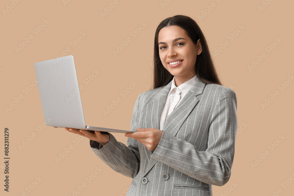 Happy businesswoman with laptop on beige background