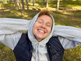 Wall Mural - portrait of a cheerful girl in the forest enjoying the weather