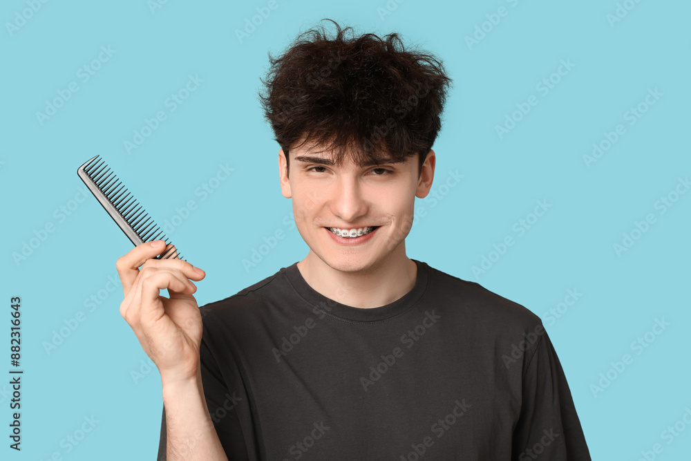 Young dark haired man with comb on blue background