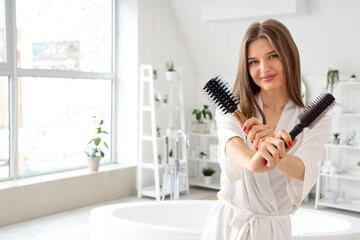 Poster - Beautiful young woman with round hair brushes in bathroom