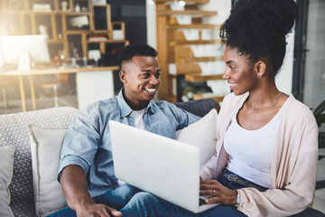 Laptop, happy and black couple in home for internet, online shopping and ecommerce website on sofa. Dating, relationship and man and woman on computer for bonding, chill and relax in living room