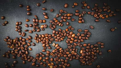 Wall Mural - Coffee beans on a dark background. Fresh roasted coffee beans closeup on black stone background. Top view, flat lay with copy space