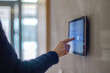 © Александр Марченко - Woman using smart home automation system on wall mounted tablet