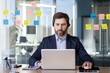 © Liubomir - Serious and focused man with headset phone works inside office with laptop, businessman in business suit mature worker thinks about implementation of set decisions.