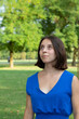 © Alessandro Grandini - Young woman wearing blue dress looking up in the park