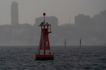 Canvas Print - Red buoy starboard  side open sea rainy foggy morning ocean