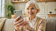 © NewFresh  - Portrait of smiling senior woman using smartphone at home. Elderly lady using mobile phone.