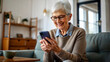 © NewFresh  - senior woman with smartphone at home in the living room at home