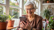 © NewFresh  - Elderly woman using a smart phone in a home environment.