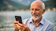 © NewFresh  - Portrait of a senior man using his mobile phone at the lake