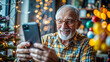 © NewFresh  - Happy senior man using mobile phone while sitting at home in front of Christmas tree