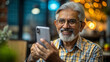 © NewFresh  - Portrait of senior man using mobile phone while sitting in coffee shop