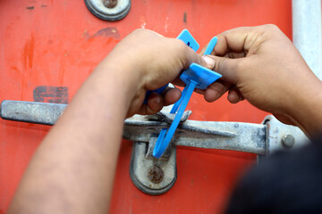 Wall Mural - officers seal the container doors after the loading process is complete. Container security seal with code number to maintain goods security during shipping.