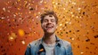 © Genius pixels - Smiling man surrounded by golden confetti on orange background joyful expression concept