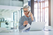 © peopleimages.com - Woman, phone call and documents with laptop in office for investment, plan or update on client finance. Mature financial advisor, discussion and work with tech for foreign exchange, trading or report