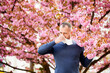 © anatoliy_gleb - Man allergic suffering from seasonal allergy at spring in blossoming garden at springtime. Man sneezing and blowing nose using nasal handkerchief in front of blooming tree. Spring allergy concept.