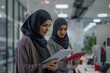 © Feri - Two Businesswomen in Hijab Working on Tablets