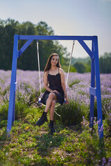 Wall Mural - Young woman in a swing in a lavender field