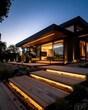 ©  Green Creator - Modern home with outdoor lighting and a tractor in the driveway at dusk.