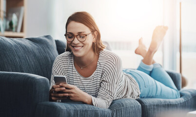 Relax, smile and woman on sofa with phone for text, funny group chat and social media at home. Female person, mobile and happy on weekend for communication, ecommerce or sale on online shop in lounge