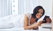 © peopleimages.com - Woman, bed and morning with smartphone in house, happy and silence mobile alarm in bedroom. Message, notification and text on social media, scrolling and weekend for communication or reading blog