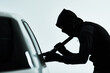 © peopleimages.com - Man, car and steal attempt with criminal, automobile and flash light or checking for valuable possession inside. Illicit, assessing vehicle and security for anti theft system, hooded and parking lot