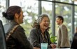 © Zeenat - Business people laugh in meeting, manager near desk.