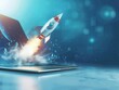 © Jelena - futuristic rocket emerging from laptop screen symbolizing innovation dynamic composition with sleek design cool blue background with space for text tech concept with sense of possibility