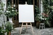 © SH Design - A large white blank canvas on an easel at the entrance of the wedding venue