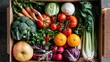 © svastix - A cardboard box packed with a colorful variety of fresh fruits and vegetables including apples, broccoli, carrots, tomatoes, oranges, and green leafy vegetables.