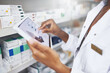 © JorSons/peopleimages.com - Person, hands or tablet with screen in drug store for stock inspection, report for medicine inventory. Female pharmacist, pharmacy or mockup for digital record of health information or pills research