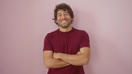 Sticker - Young hispanic man wearing t shirt standing happy face smiling with crossed arms looking at the camera. positive person. over isolated pink background