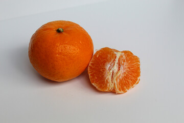 Comparison of orange fruit before and after peeled, isolated on white background