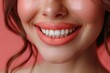 © AlirezA - A woman smiles broadly, showcasing her bright white teeth and coral lipstick. Her skin is smooth and glowing