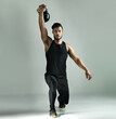 © ThurstanBuyout/peopleimages.com - Man, athlete and kettlebell in portrait, workout and gray background for health, strong muscle or wellness. Male person, lunges and training routine in weight lifting, cardio or bodybuilder in studio