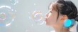 © VizGen - A girl blowing bubbles, her face glowing with delight against a white background